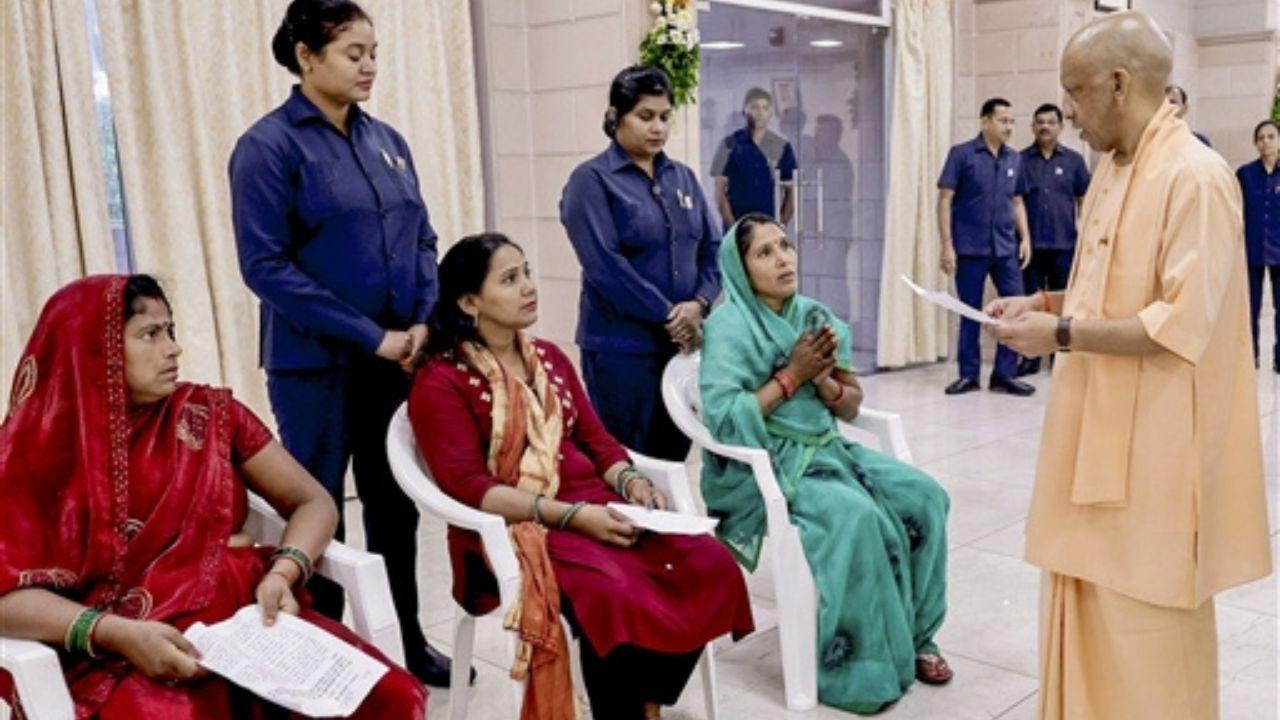 Uttar Pradesh Chief Minister Yogi Adityanath, right, listens to the grievances of citizens during a 'Janata Darshan' at his official residence, in Lucknow, Uttar Pradesh. Pic/PTI